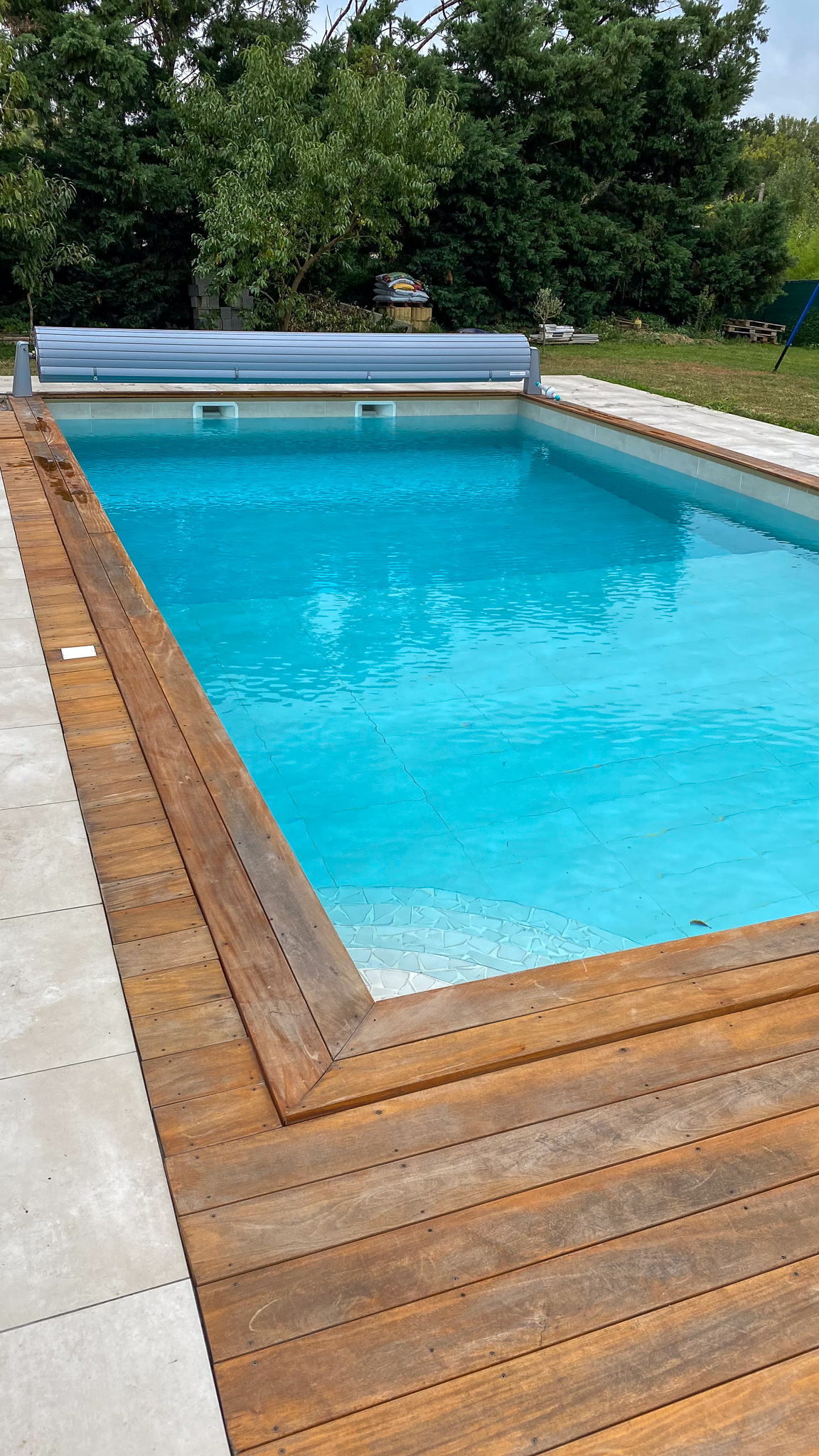 Piscine rectangulaire avec volet roulant et plage bois