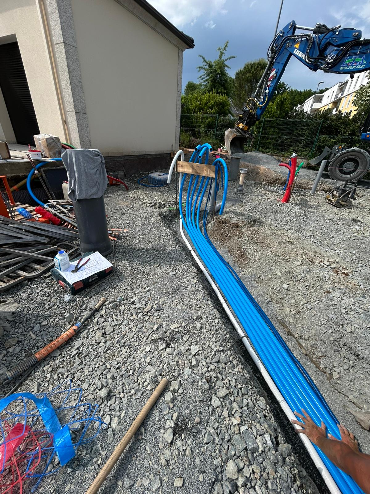 Terrassement, tuyaux PE bleus en tranchée, mini-pelle