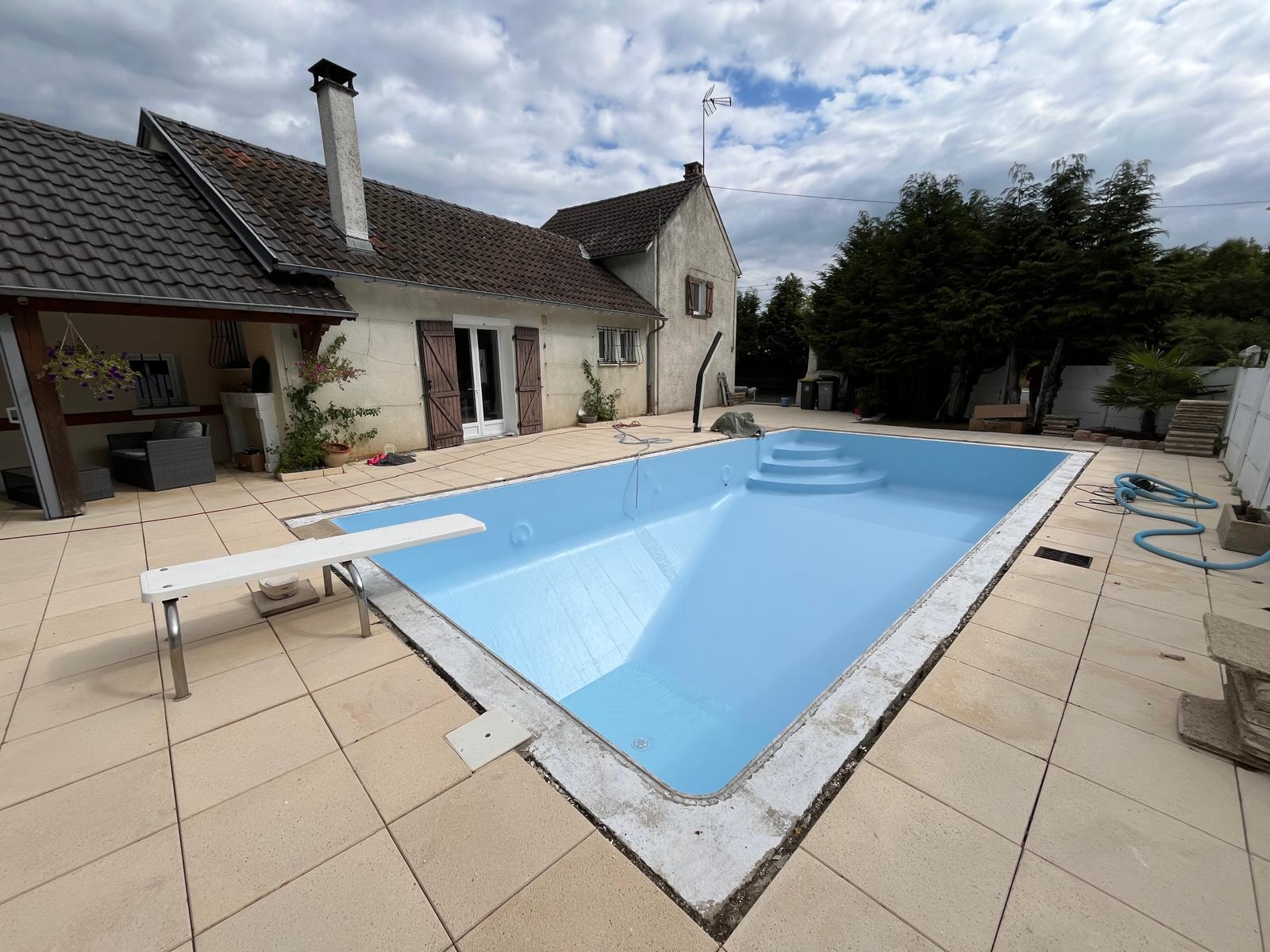 Bassin rénové rempli d'eau claire, liner bleu ciel posé