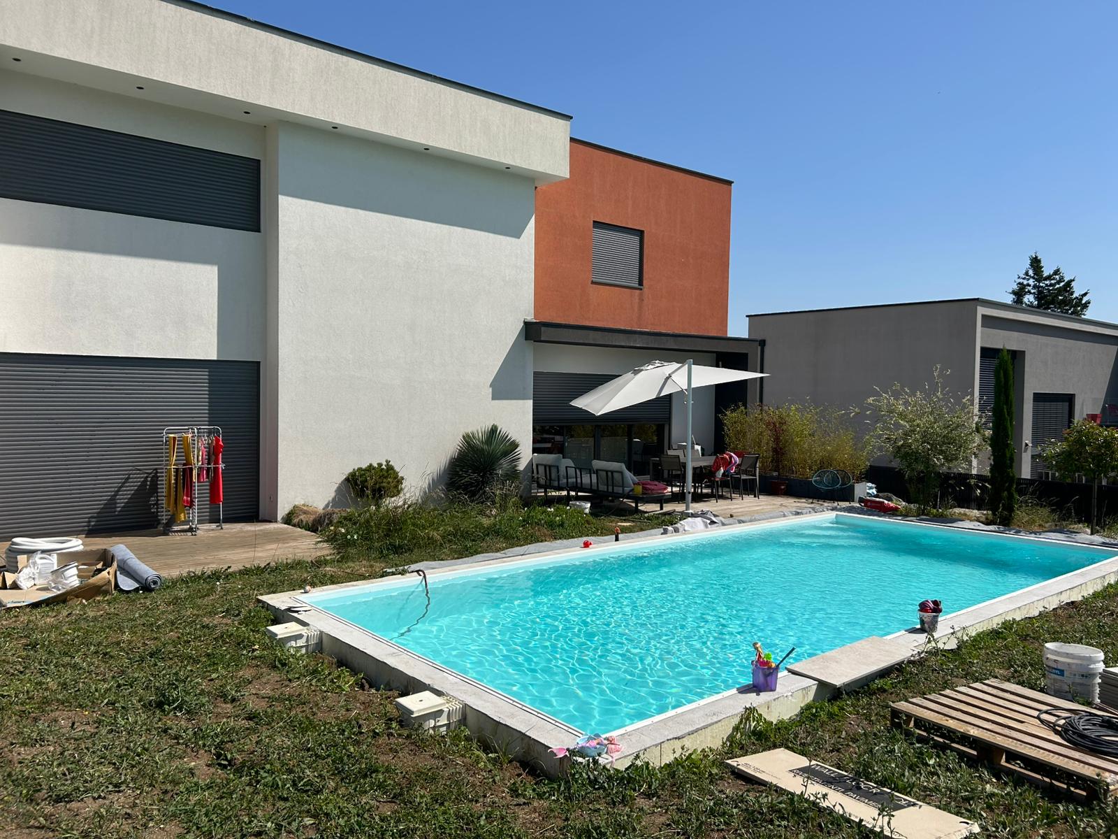 Piscine neuve devant maison cubique orange
