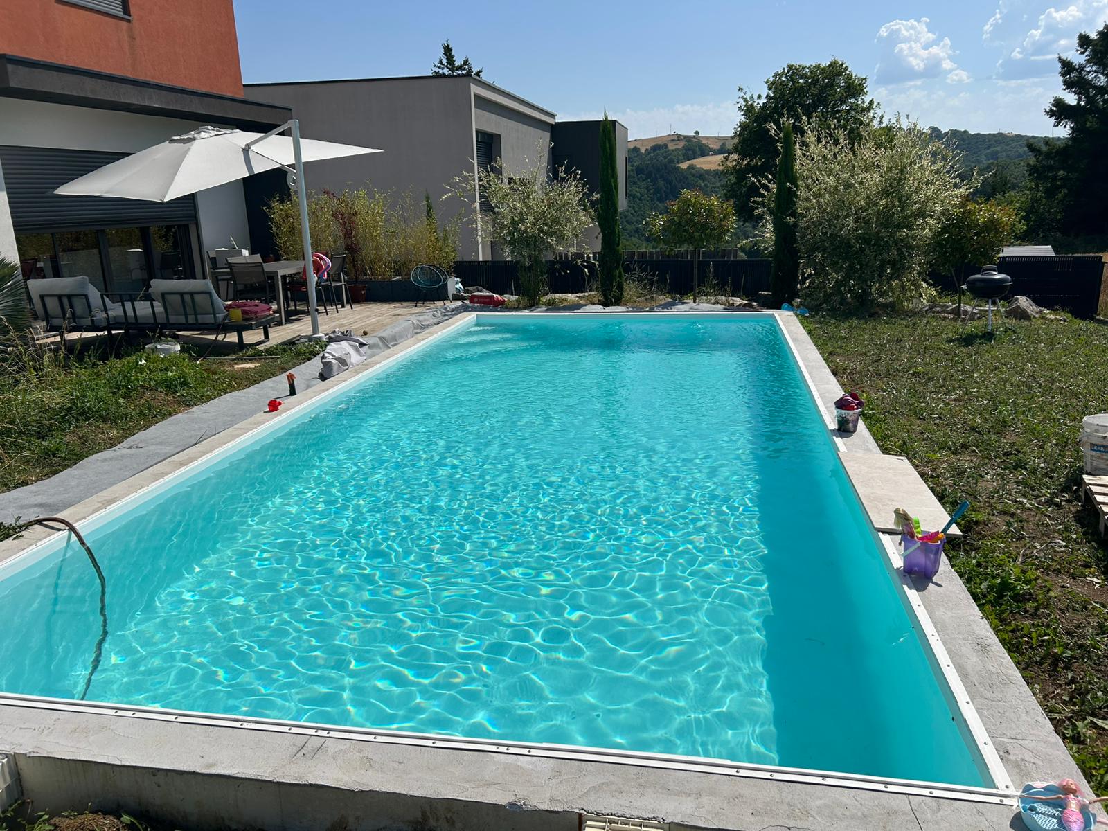 Piscine en plein été, parasols, maison contemporaine