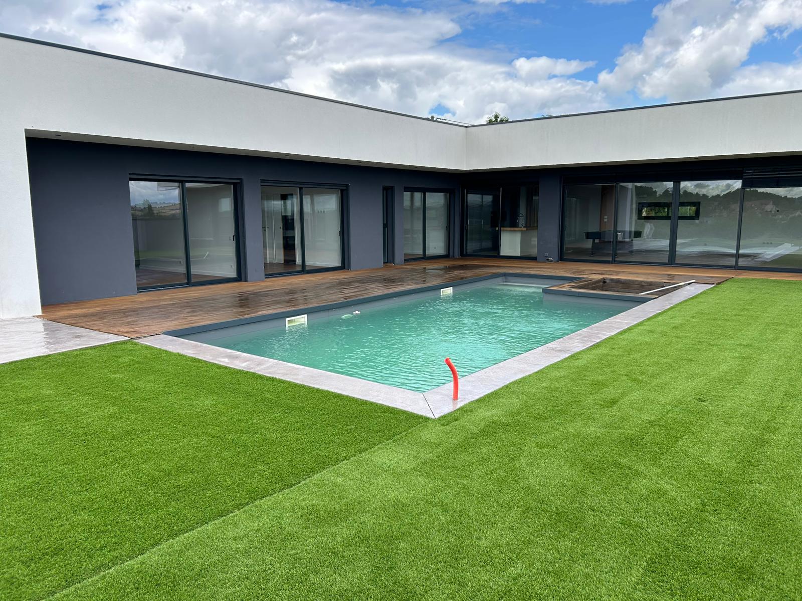 Piscine moderne avec gazon synthétique autour