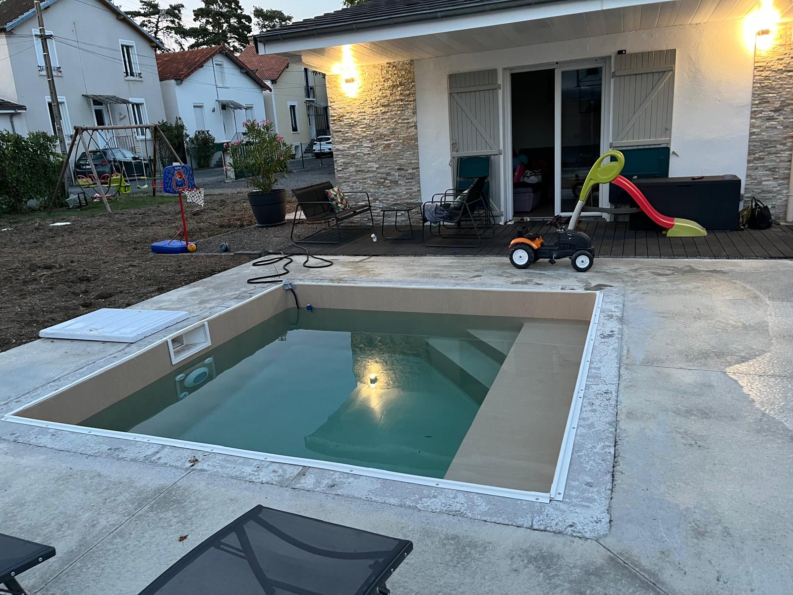 Petit bassin familial en eau à la tombée du jour