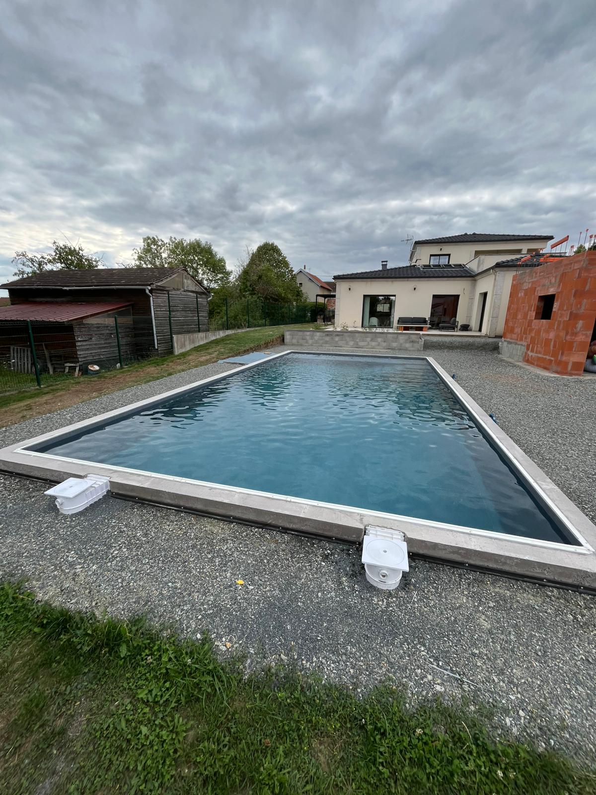 Piscine turquoise devant maison contemporaine terracotta